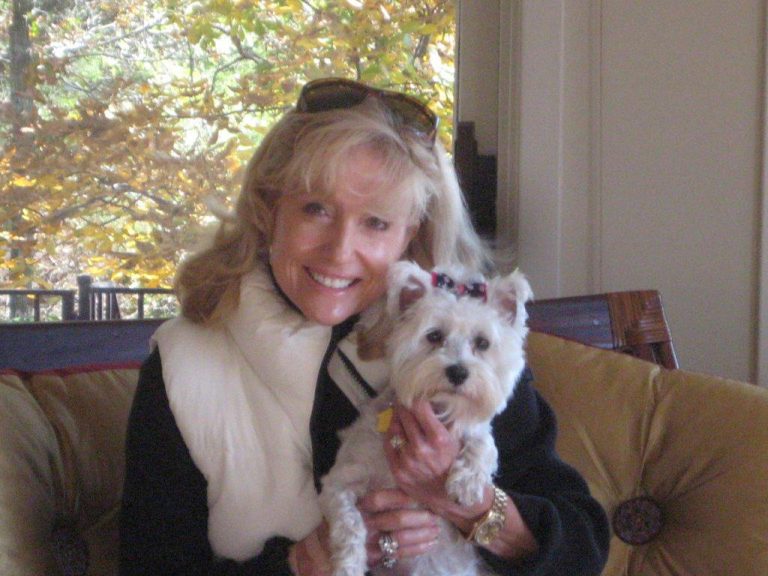 Charlotte Bailey Rierson smiling with her small white dog Bella
