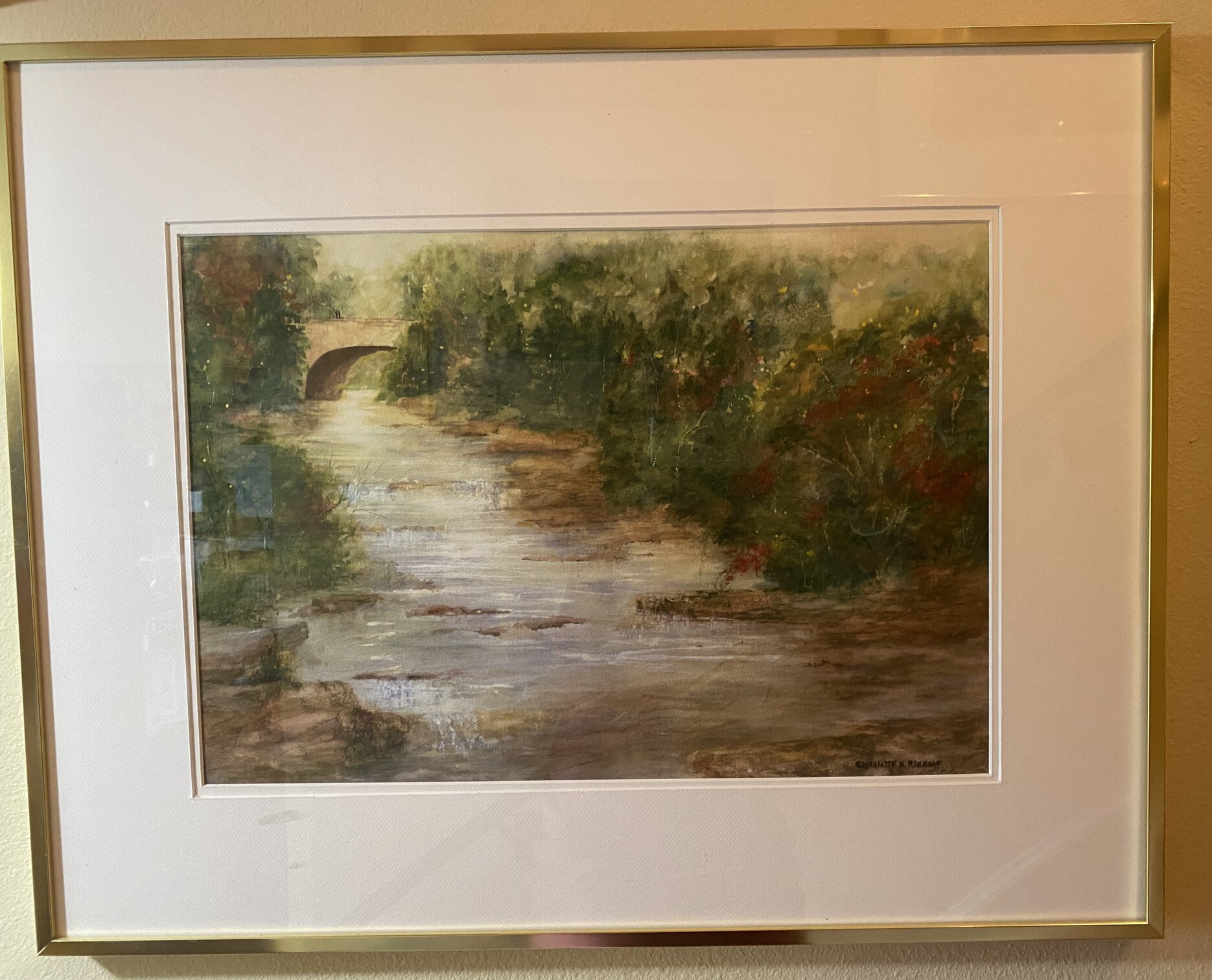 Watercolor river landscape with trees and a bridge in the distance