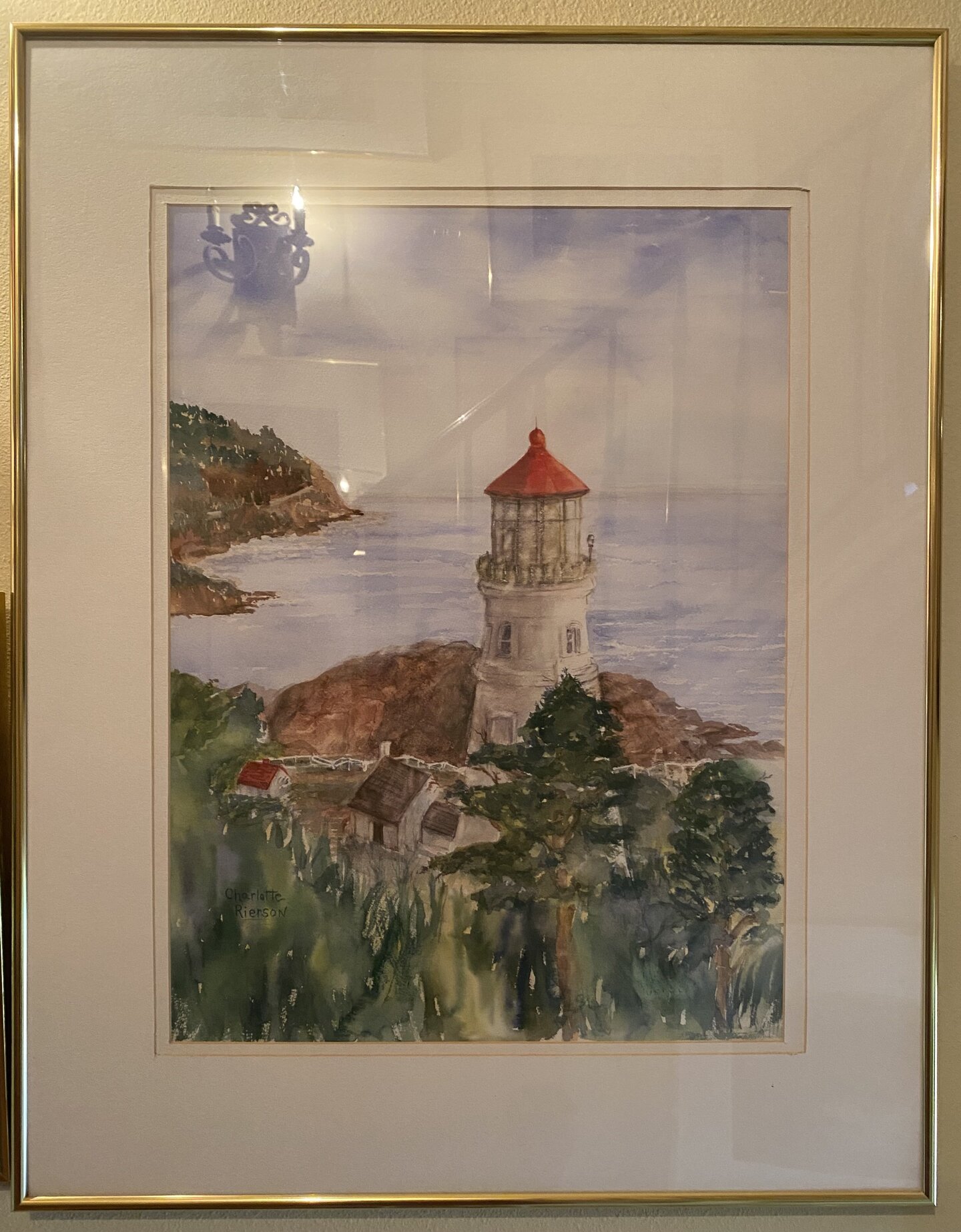 Watercolor coastal lighthouse with red roof overlooking the ocean